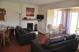 a living room with a couch and a table and chairs at Ardamine Holiday Homes in Courtown