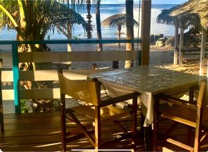 een tafel en stoelen op een strand met uitzicht op de oceaan bij Le 35 Anse des Rochers Saint-François in Saint-François