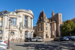 a large building with cars parked in a parking lot at Appar Quartier Calm Coeur de Ville in Agen