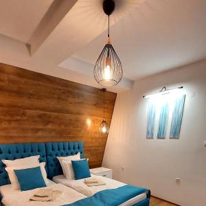 Къща за гости Радост Guest House Radost في رازلوغ: غرفة نوم مع سرير بلوحة راس زرقاء