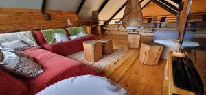 salon z czerwoną kanapą i drewnianymi stołkami w obiekcie Rumbo Sur Hotel w mieście Villa O'Higgins