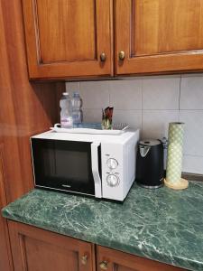 a white microwave sitting on a counter in a kitchen at Splendido appartamento in zona centrale in Alessandria +26 photos