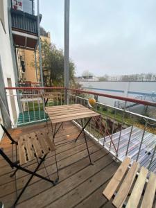 eine Holzterrasse mit einem Picknicktisch und zwei Bänken in der Unterkunft Blue Chili 04 - MD Top City Apartment - WiFi in Magdeburg