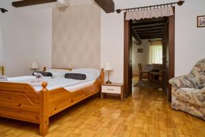 1 dormitorio con cama de madera y sofá en Kölcsey Vendégház en Hódmezővásárhely