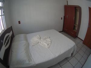 a bedroom with a bed with a bow on it at Olhar da Barra Hospedagem - Casa Branca in Florianópolis