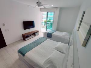 een ziekenhuiskamer met 2 bedden en een televisie bij Apartamento con vista al mar in Cartagena
