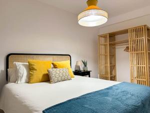 een slaapkamer met een bed met gele en blauwe kussens bij Creatividad y personalidad en centro de Alicante in Alicante