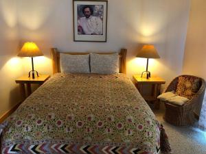 a bedroom with a bed and two lamps and a chair at River Run Inn in Winthrop