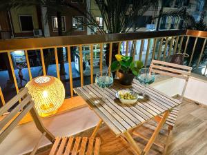 een houten tafel en stoelen op een balkon bij Creatividad y personalidad en centro de Alicante in Alicante