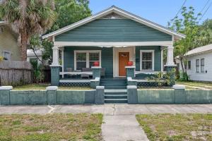 a blue house with a front porch with a red door at Wonderful 3 Bed 2 Bath House in Heart of YBOR City in Tampa