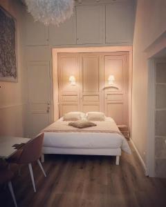 a bedroom with a bed and a table and a chandelier at Coeur de Calignac in Calignac +29 photos