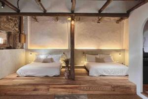 two beds in a room with wooden floors and ceilings at Twilight Stone in Jiufen