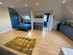 ein Wohnzimmer mit einem blauen Bett und Holzboden in der Unterkunft Lovely spacious loft close to train station in Worthing