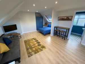 a living room with a couch and a table at Lovely spacious loft close to train station in Worthing