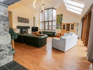 a large living room with couches and a tv at Ddol Helyg Barn in Cwm-y-glo