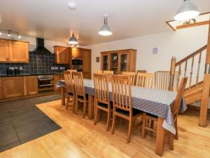 a kitchen with a table and chairs in a room at Ddol Helyg Barn in Cwm-y-glo