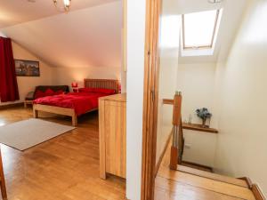 Cwm-y-glo的住宿－Ddol Helyg Barn，一间卧室设有红色的床和窗户。