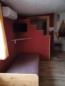 Habitación con escalera y pared roja. en Málnás Szállás, en Dunavarsány