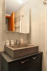 uma casa de banho com um lavatório e um espelho em 4 Valleys- Charming apartment 6 people 150m from the gondolas em Nendaz