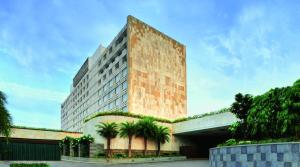 a tall building with palm trees in front of it at Taj Coromandel in Chennai