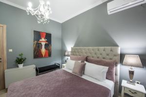 una camera con letto e lampadario a braccio di Luxury katrinas apartment with outdoor jacuzzi a Città di Corfù