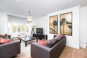 een woonkamer met 2 banken en een tv bij ' Luxury & Spacious 4 Bed 4 Bath Apartment ' in Londen