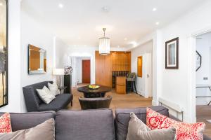 een woonkamer met een bank en een tafel bij ' Luxury & Spacious 4 Bed 4 Bath Apartment ' in Londen
