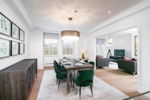 een eetkamer met een tafel en groene stoelen bij ' Luxury & Spacious 4 Bed 4 Bath Apartment ' in Londen