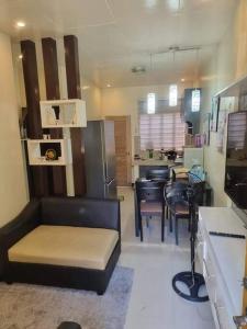 Entire House - Daet (Fully Furnished) في Daet: غرفة معيشة مع أريكة وغرفة طعام