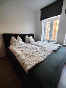 een groot bed in een slaapkamer met een groot raam bij Neu sanierte Wohnung mit Balkon und Stellplatz in Erfurt