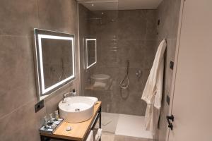 a bathroom with a sink and a shower at Modica Boutique Hotel in Modica