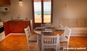 eine Küche und ein Esszimmer mit einem Tisch und Stühlen in der Unterkunft Apto Mar de Es Caló, a metros de la playa - Formentera Natural in Es Caló