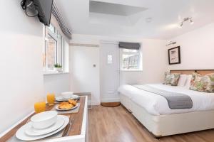 Un dormitorio con una cama y una mesa con comida. en Modern Self Contained Studio Home, en Cheltenham