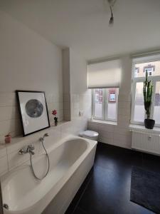 een witte badkamer met een bad en een toilet bij Neu sanierte Wohnung mit Balkon und Stellplatz in Erfurt +7 foto's