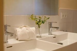 a bathroom sink with a vase with a plant in it at Finca Son Sureda Agroturismo in Manacor