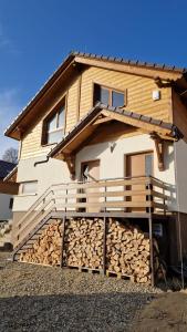ein Haus mit einem Stapel Holz davor in der Unterkunft Mytho 2 in Mýto pod Ďumbierom