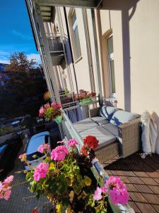 een veranda met een bank en bloemen op een balkon bij Neu sanierte Wohnung mit Balkon und Stellplatz in Erfurt