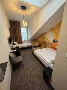 um quarto de hotel com uma cama, uma secretária e uma cadeira em Bursztynowa em Łuków
