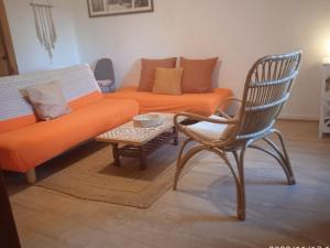 een oranje bank en een stoel in de woonkamer bij Casa tia Juanita in Calaceite