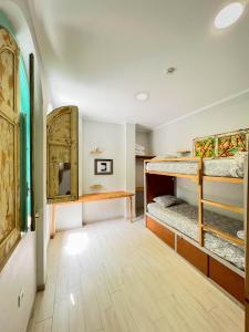 Zimmer mit 2 Etagenbetten und einem Schreibtisch in der Unterkunft Kali Vice Surf Villa in Costa da Caparica