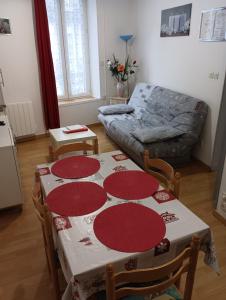 a living room with a table and a couch at VILLA DUCHATEL in Le Mont-Dore