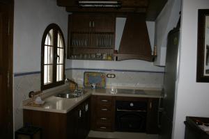 Una pequeña cocina con fregadero y ventana. en Casa Lentegí, en Lentegí