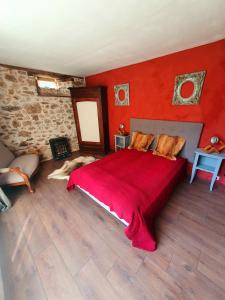 ein rotes Schlafzimmer mit einem Bett mit einer roten Wand in der Unterkunft Gite de la Genevrière in Saint-Chamant
