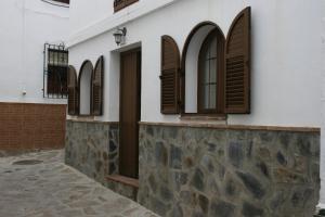 un edificio blanco con persianas marrones en él en Casa Lentegí, en Lentegí