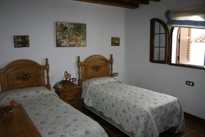 Un dormitorio con dos camas y una ventana. en Casa Lentegí, en Lentegí