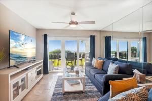 sala de estar con sofá azul y TV en Land's End 7-203 Beach Front - Premier, en St Pete Beach