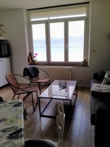 un soggiorno con tavolo, sedie e finestra di Appartement Cosy a Ault