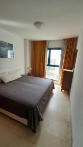 pokój hotelowy z łóżkiem i oknem w obiekcie Precioso apartamento con piscina cerca de la playa w mieście Benidorm