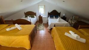 a room with three beds with white towels on them at Quinta Amaro AL in Angra do Heroísmo