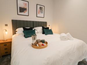 a white bed with a tray of food on it at Bracken Cottage in York